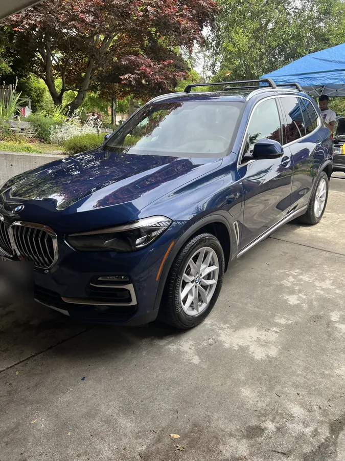 Blue BMW X5 freshly detailed in the driveway